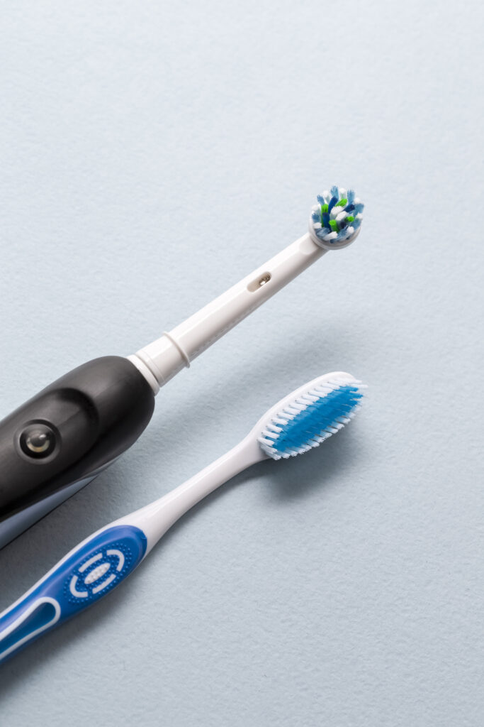 Mechanical and manual toothbrush being compared side by side.