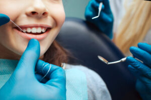 Young child being taught how to floss in dentist office