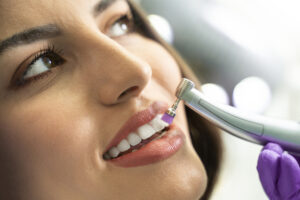 Female patient getting teeth cleaned at dentists office
