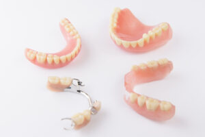 Dentist holding denture in office